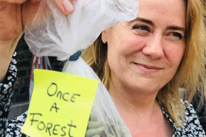 Fenna Swart van Comité Schone Lucht tijdens een demonstratie tegen biomassa met een zakje houtpellets. Once a forest (ooit een bos) staat er op het zakje. © Comite Schone Lucht